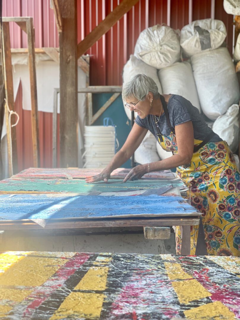 A woman is cutting paper on top of a table.