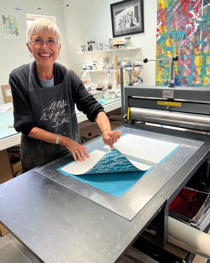 A woman is cutting paper on a machine.